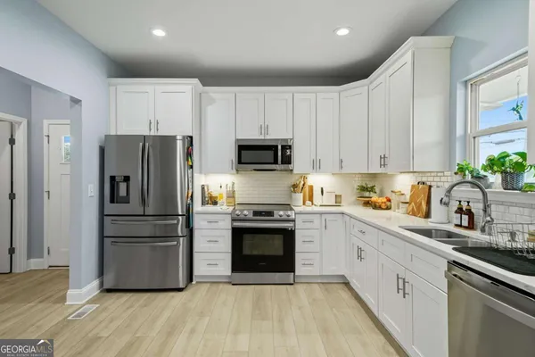 a kitchen with stainless steel appliances a refrigerator sink and microwave