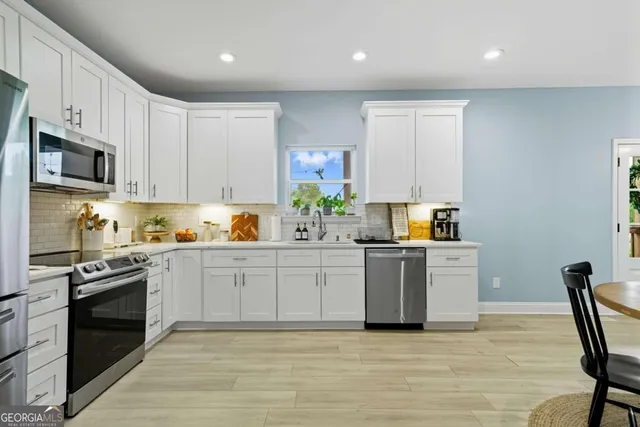 a kitchen with stainless steel appliances granite countertop a stove a sink dishwasher a microwave oven and a refrigerator