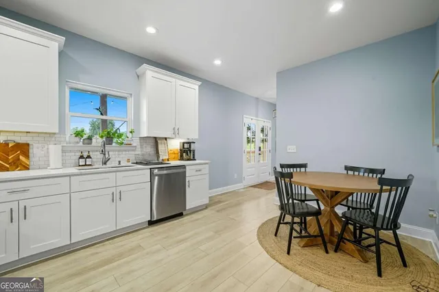 a kitchen with granite countertop white cabinets and stainless steel appliances