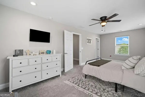 a bedroom with a bed a window and a flat screen television