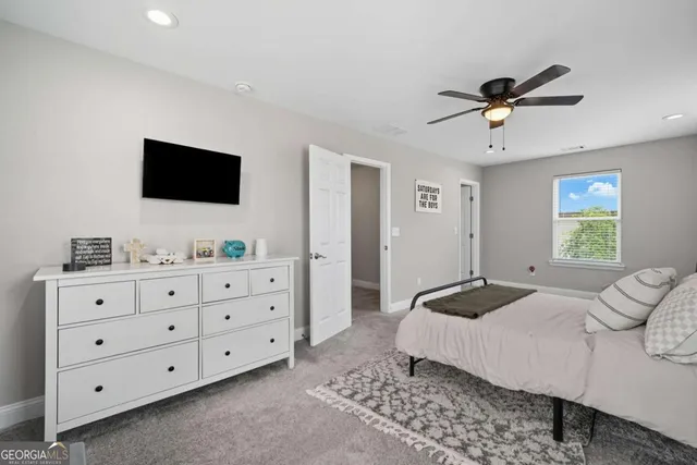 a bedroom with a bed a window and a flat screen television