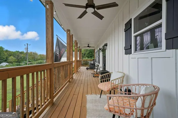 a view of a house with wooden deck and a floor to ceiling window