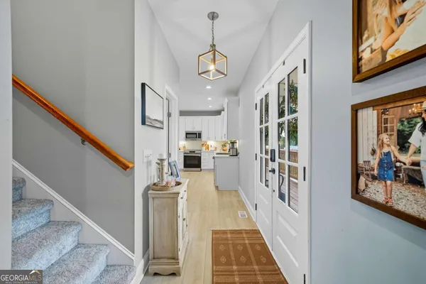 a view of a hallway with wooden floor and staircase