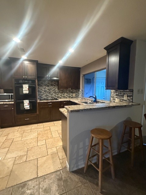 16714 Rockbend Houston, TX 77084 - Photo 7 of 19 a kitchen with stainless steel appliances kitchen island granite countertop a table chairs in it and wooden floors