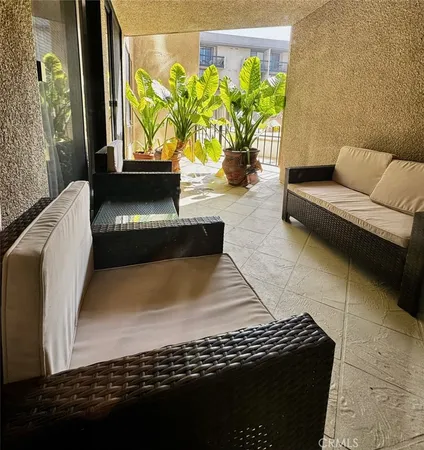 a view of a patio with table and chairs with plants and wooden fence