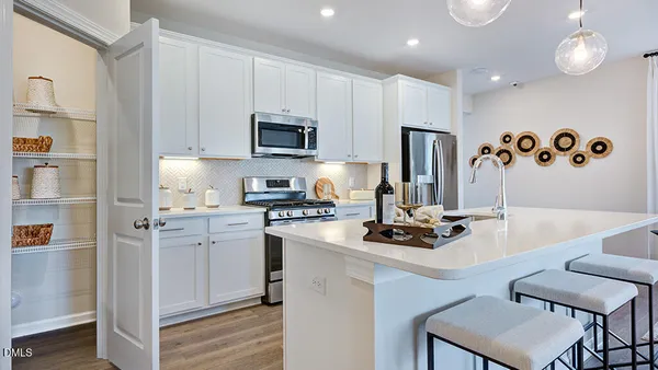 a kitchen with stainless steel appliances granite countertop a stove a sink a microwave a center island and furniture