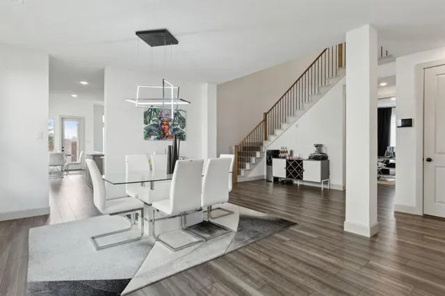a kitchen with stainless steel appliances a dining table chairs and a refrigerator