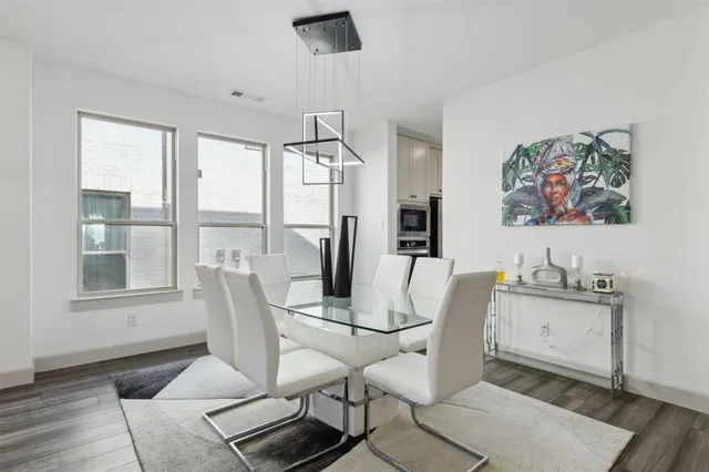a dining room with wooden floor and a chandelier