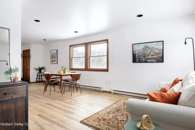 a living room with furniture and a dining table with wooden floor