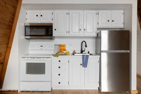 a kitchen with white cabinets and stainless steel appliances