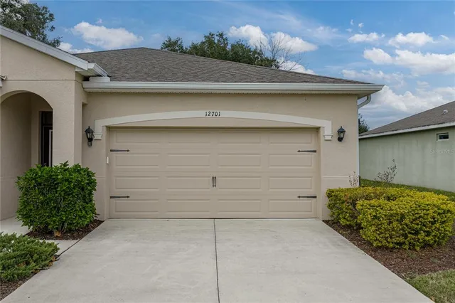 a bathroom with a granite countertop double vanity sink a mirror and a shower