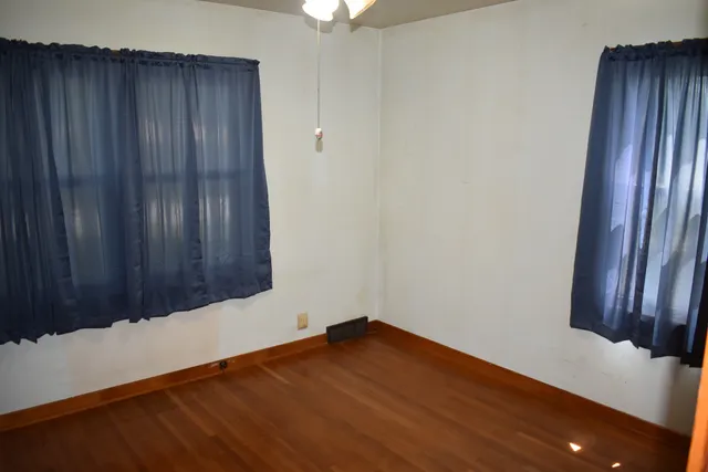 an empty room with wooden floor and closet