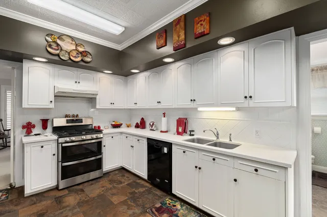 a kitchen with a stove a sink and cabinets