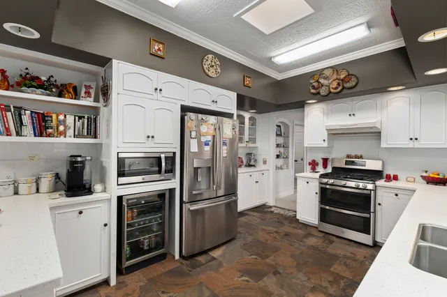 a kitchen with stainless steel appliances granite countertop a refrigerator and a stove top oven