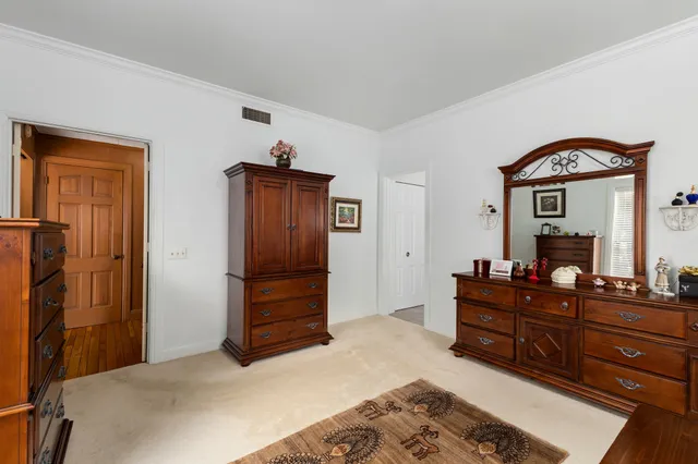 a bedroom with a dresser and a mirror