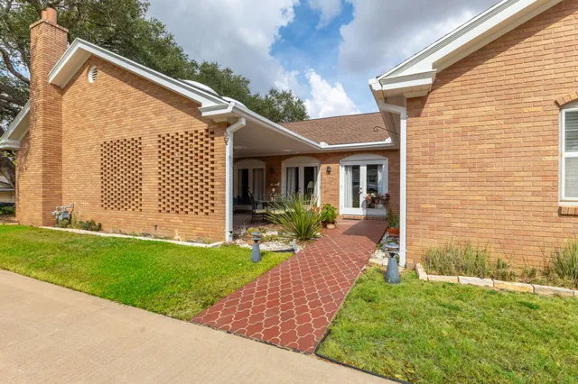 a view of a house with backyard and a tree