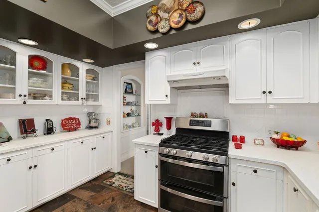a kitchen with stainless steel appliances granite countertop a stove and cabinets
