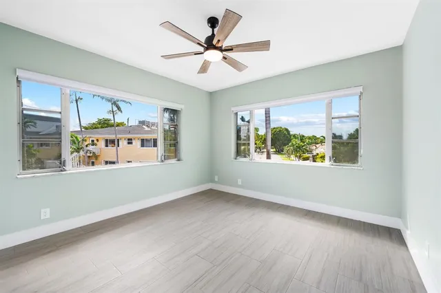 an empty room with window and ceiling fan