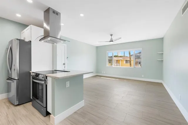 a kitchen with stainless steel appliances granite countertop a refrigerator a sink and a stove