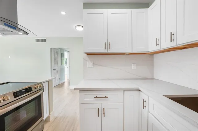 a kitchen with white cabinets and a stove