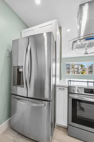 a metallic refrigerator freezer sitting in a kitchen