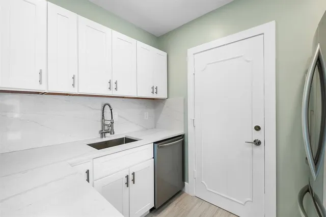 a kitchen with stainless steel appliances white cabinets and a refrigerator