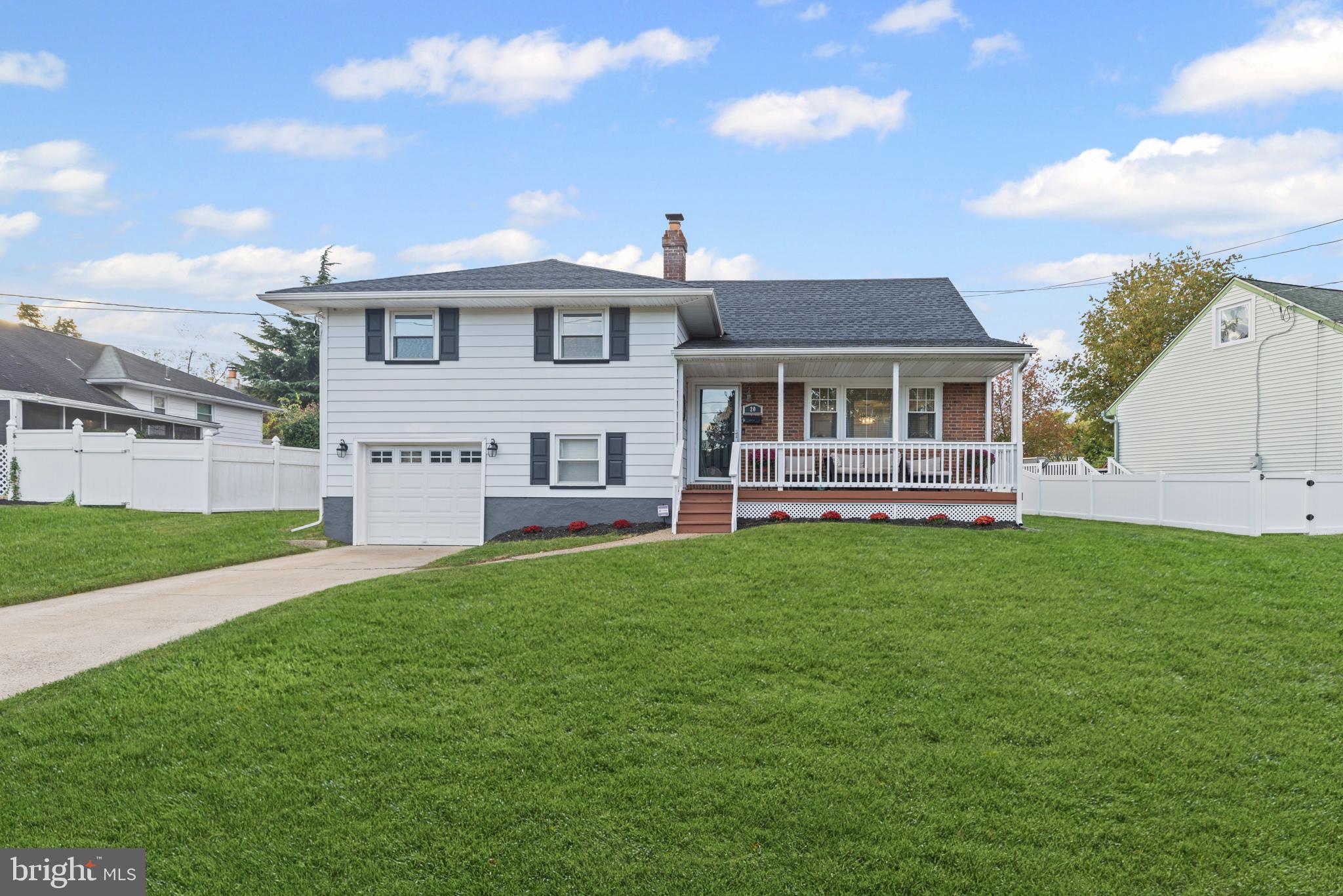 a front view of a house with a yard and lake view