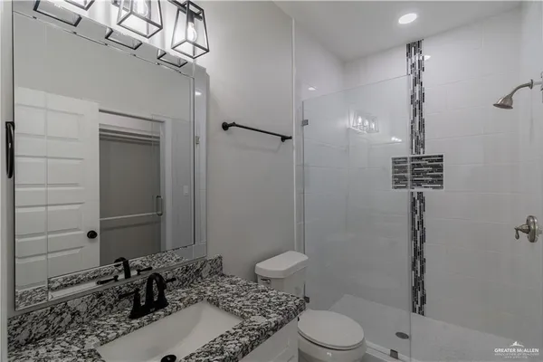 a bathroom with a sink a toilet and shower