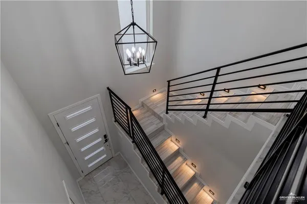 a view of a room with windows and chandelier fan