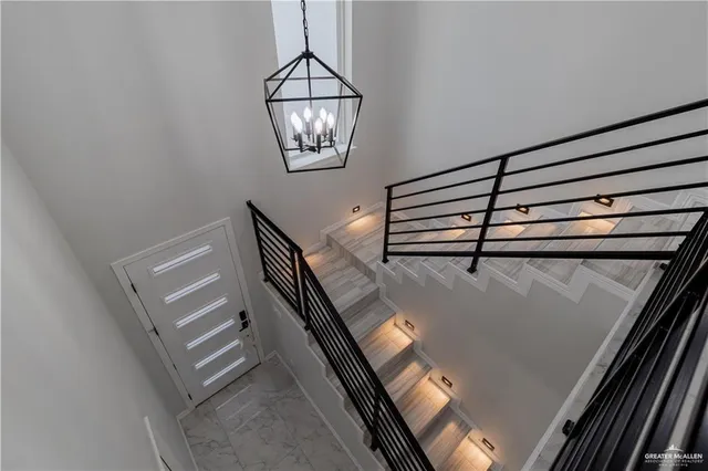 a view of a room with windows and chandelier fan