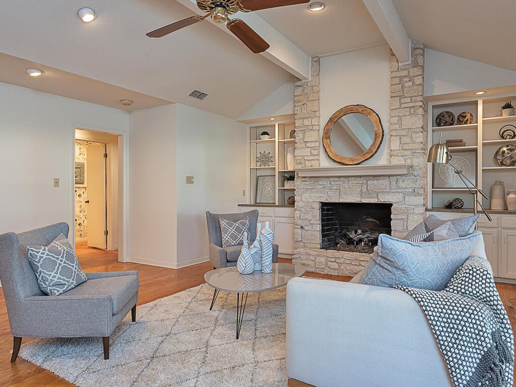 a living room with furniture a clock and a fireplace