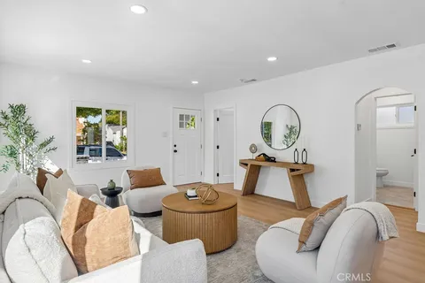 a living room with furniture a window and a lamp