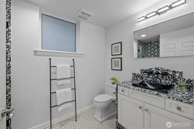 a living room with stainless steel appliances furniture and a wooden floor