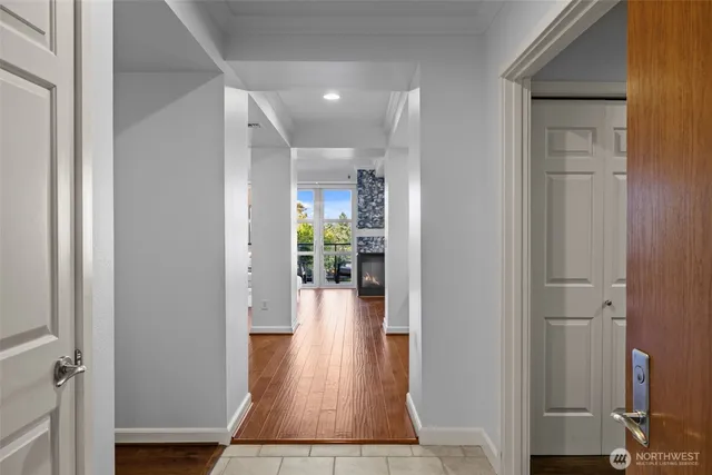 a view of a hallway with wooden floor and a livingroom with furniture