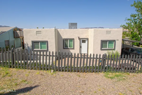 a view of a house with wooden fence