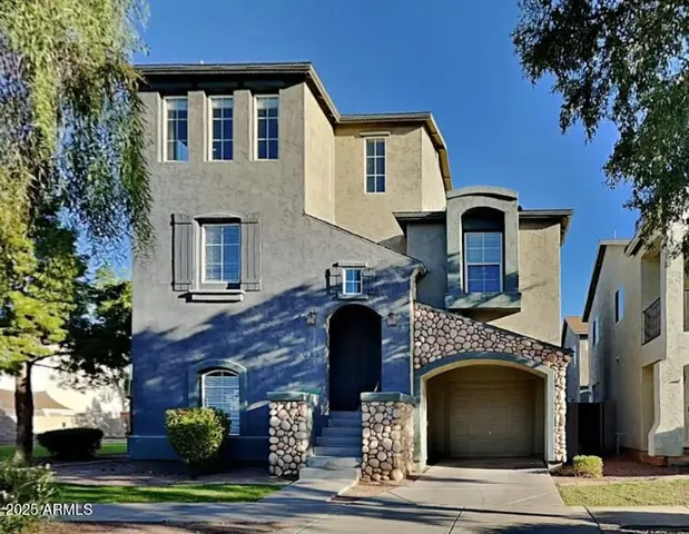 a front view of a house with plants and garage
