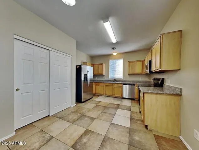 a large kitchen with cabinets and stainless steel appliances