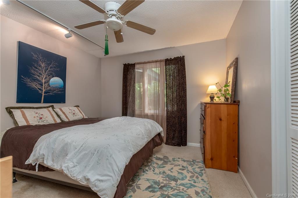 1235 Braewick Road Tryon, NC 28782 - Photo 12 of 22 a bedroom with a bed and a chandelier