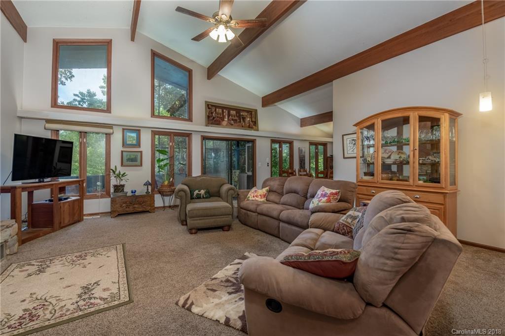1235 Braewick Road Tryon, NC 28782 - Photo 3 of 22 a living room with furniture a flat screen tv and a chandelier