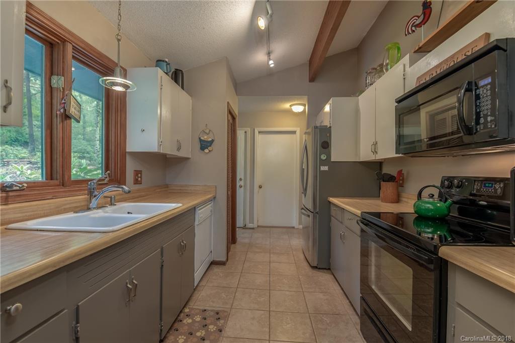 1235 Braewick Road Tryon, NC 28782 - Photo 6 of 22 a kitchen with stainless steel appliances granite countertop a sink stove and cabinets