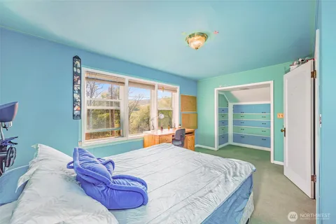 a bed sitting in a bedroom next to a window