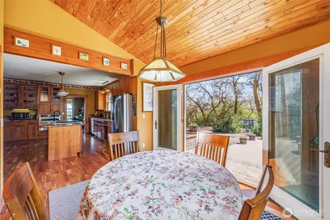 a view of a dining room with furniture large windows and wooden floor