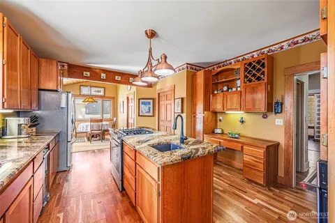 a kitchen with granite countertop a sink stove and refrigerator