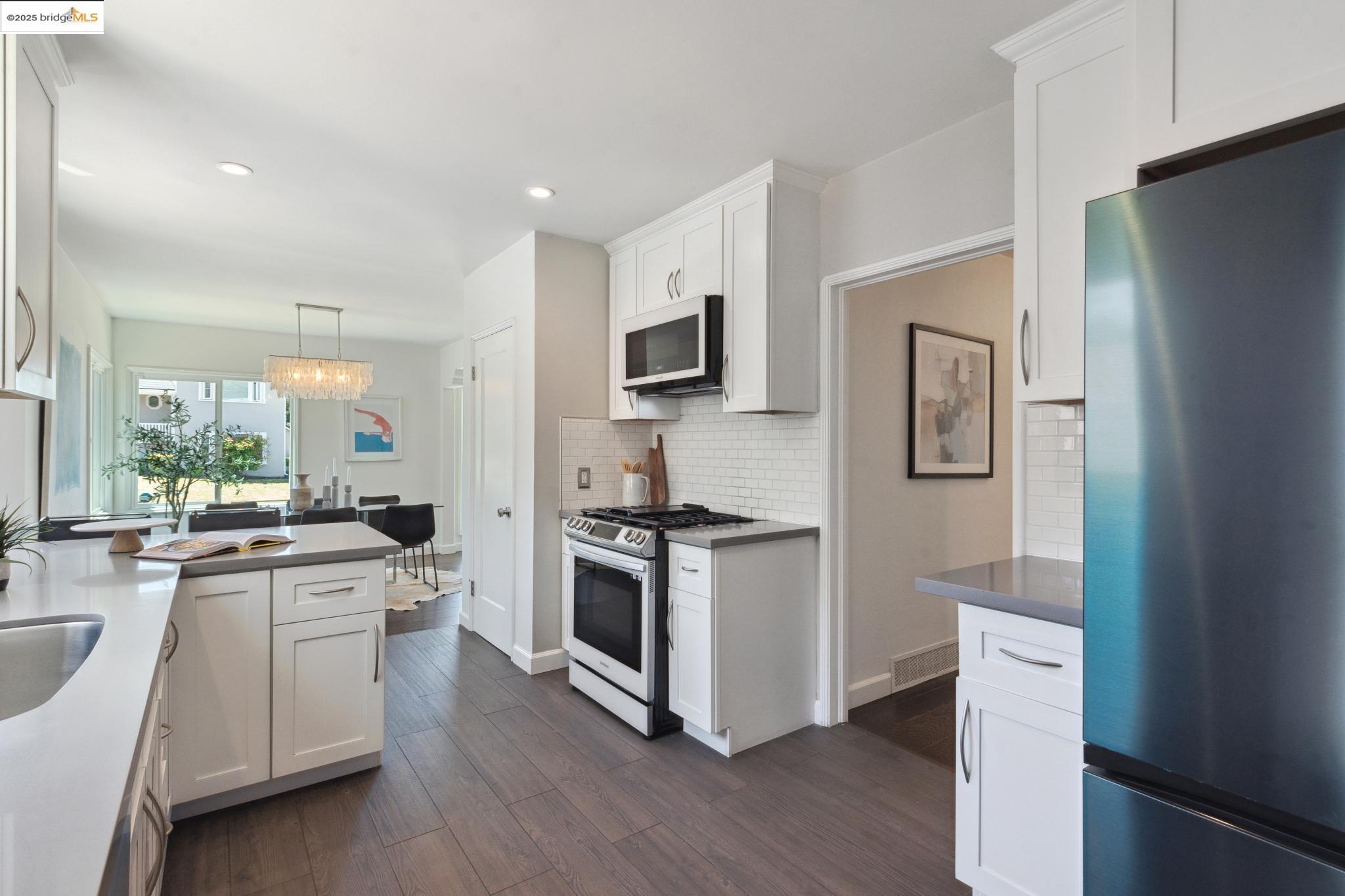 Undisclosed Address Oakland, CA 94619 - Photo 16 of 60 a kitchen with white cabinets and stainless steel appliances