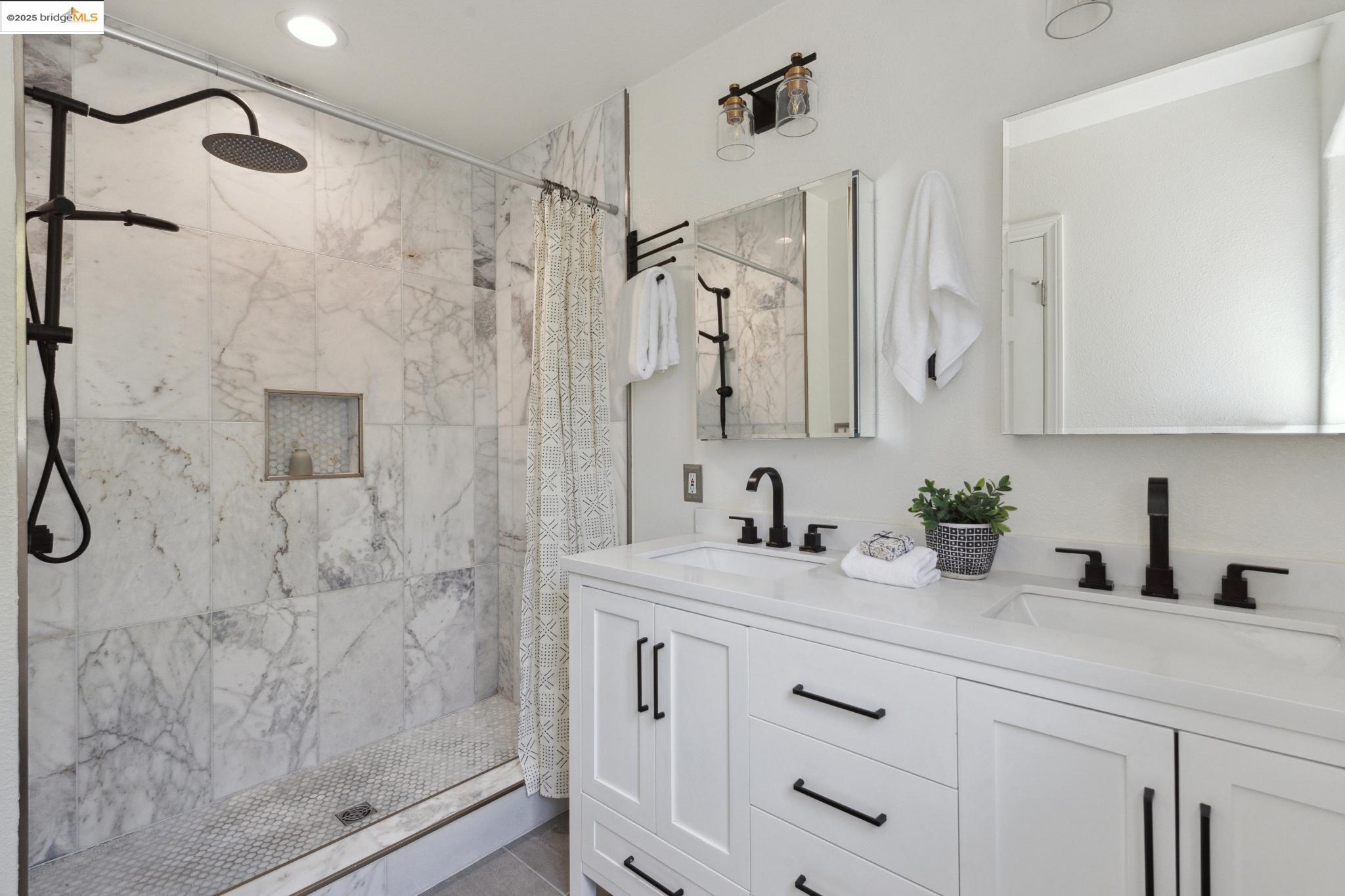 Undisclosed Address Oakland, CA 94619 - Photo 22 of 60 a bathroom with a granite countertop sink a mirror a glass door a shower and vanity
