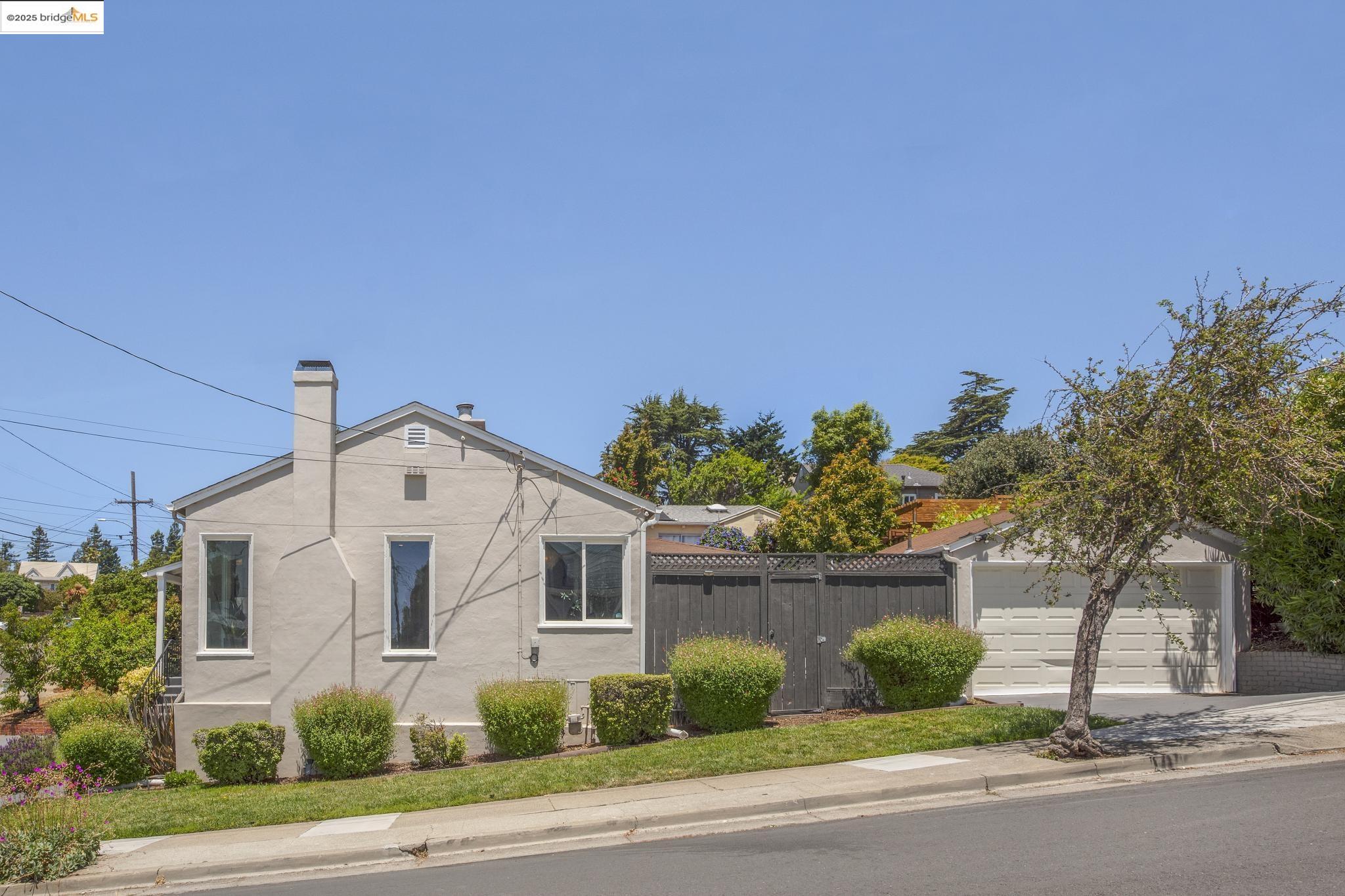 Undisclosed Address Oakland, CA 94619 - Photo 50 of 60 a front view of a house with a yard and garage