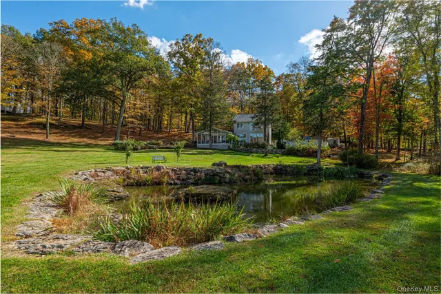 a view of a lake with a yard and large trees
