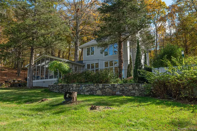 a front view of a house with a yard and tree