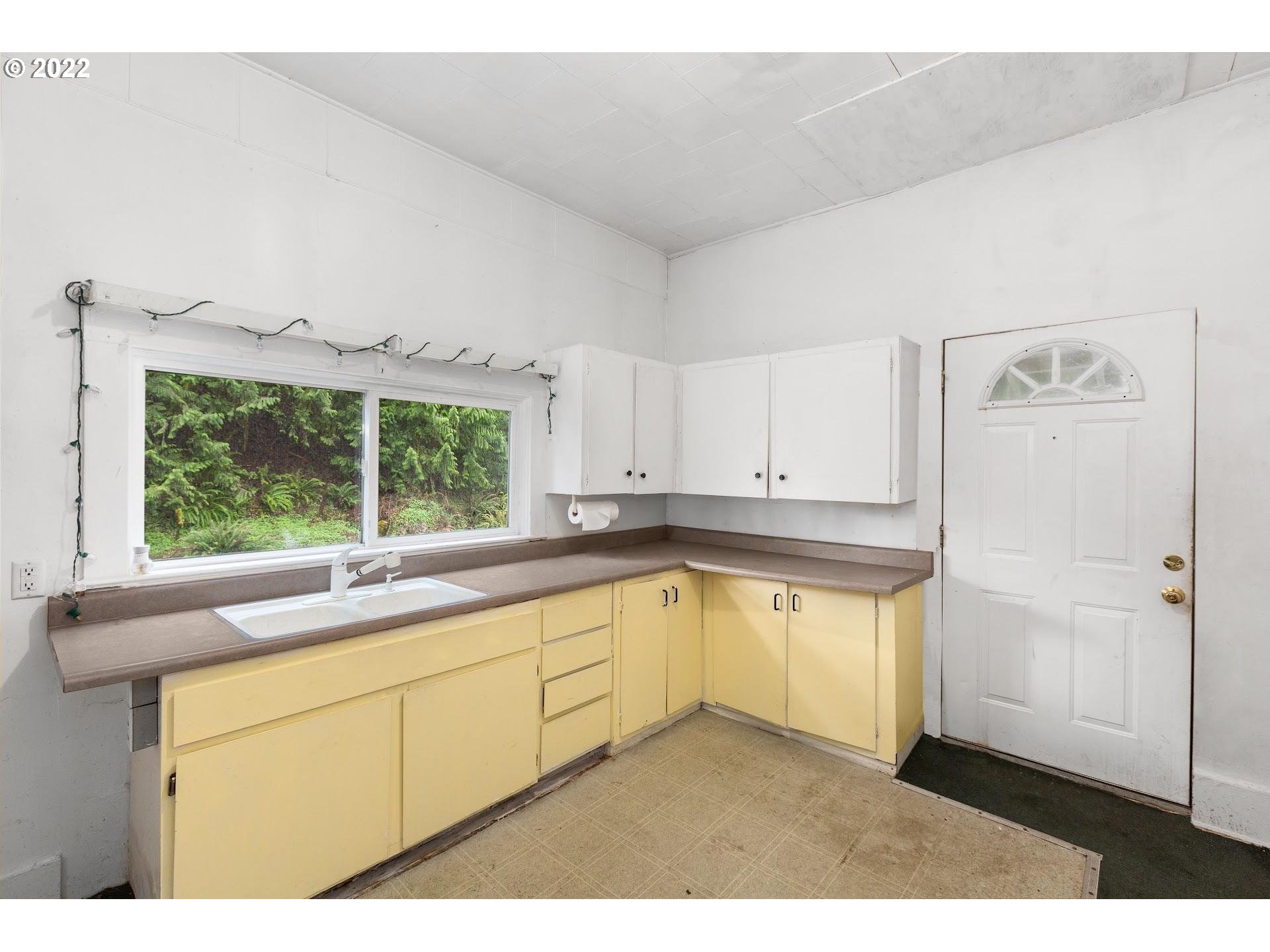 15055 Northwest Cornelius Pass Road Portland, OR 97231 - Photo 3 of 13 a kitchen with granite countertop white cabinets and white appliances