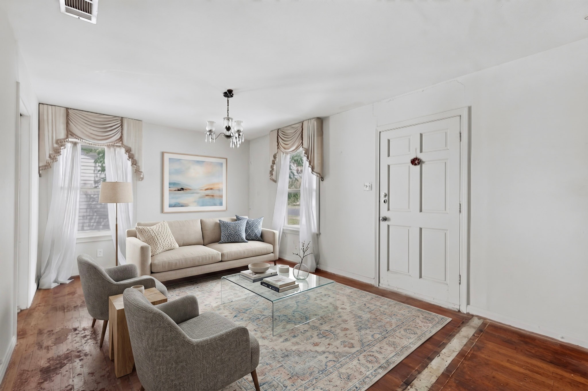 4703 Leslie Avenue Austin, TX 78721 - Photo 3 of 34 A well-lit living space features hardwood floors, large windows, and a classic chandelier.